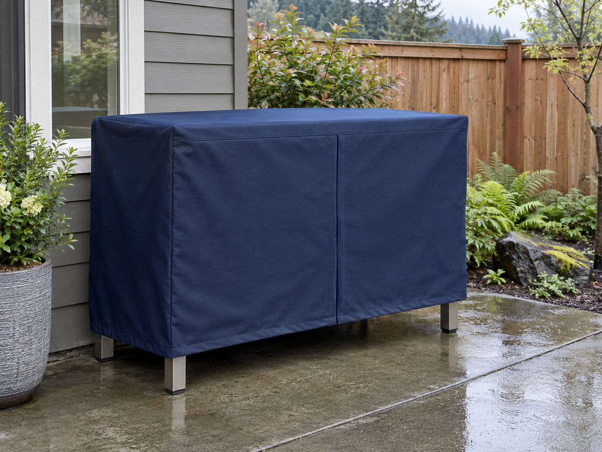 Light gray fitted cover on a low outdoor cabinet beside a home patio