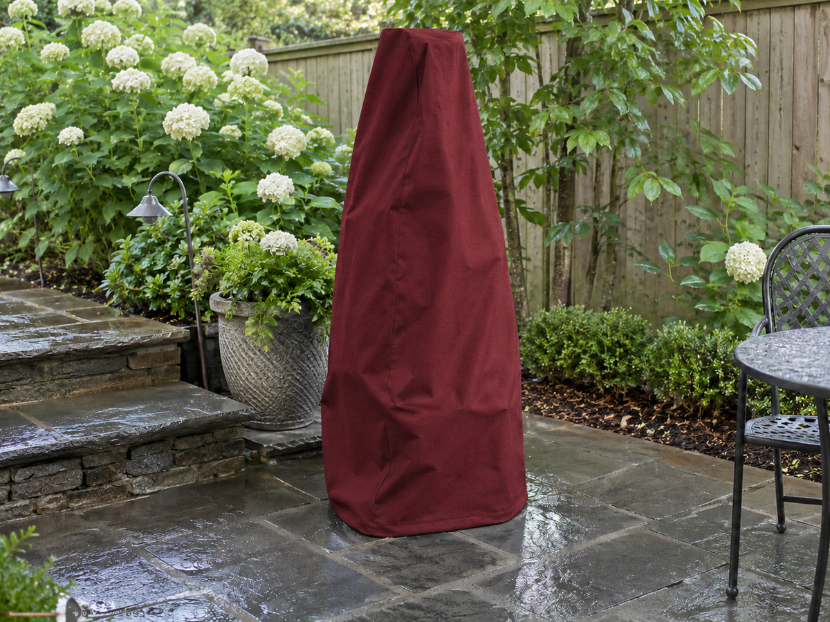 Burgundy custom cover over a tall outdoor fountain in a landscaped yard